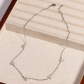 Detailed view of silver necklace with star pendants and clear zircons in a jewelry box - White Flower - Platinum