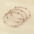 Detailed top view of three rose gold titanium bracelets with sliding beads on neutral background - Inner Diameter 60mm / 3 Rings / Rose Gold