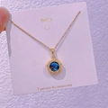 Dettaglio della collana dorata con pendente galassia blu e pietre in zircone lucido - Nebulosa Rotonda (XK004)