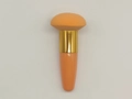 Orange mushroom head beauty sponge brush with gold metal ferrule on white background - Orange