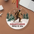 Bigfoot Christmas ornament with Squatching Through The Snow text and a red hanging ribbon - Bigfoot Squatching Through Snow
