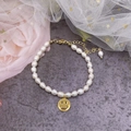 Elegant freshwater pearl bracelet featuring a golden smiley face charm and adjustable chain - Smile Bracelet