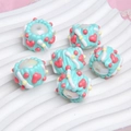Close-up of light blue resin DIY beads with pink heart patterns and cream frosting details - White Bead + Green Cream + Watermelon Red Heart