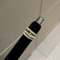 Détail de bagues en perles vintage dorées superposées sur un présentoir - Style Perle Dorée