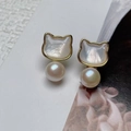 Macro shot of cat-shaped gold earrings with iridescent shell inlay and white pearls - Stud Earrings