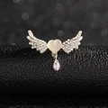 Detailed view of heart-winged gold brooch with white rhinestones and opalescent stone - Angel Wings Brooch