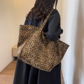 Stylish large leopard print canvas tote bag with wide shoulder straps worn by a model - Brown Leopard