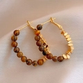 Detail of 18k gold plated hoop earrings featuring brown tiger eye beads on beige fabric - 4# Metal Tiger Eye Beaded Style (4#)