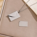 Zilveren envelop medaillon ketting met hanger op een gestructureerd beige oppervlak - Eenvoudige Envelop / Zilver