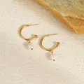 Macro detail of French style gold hoop earrings with white pearls on a stone background - 18K Gold / Gold Freshwater Pearl C-Hoop