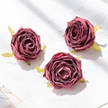 Three deep red artificial rose heads for DIY crafts on a textured paper background - Rose Gold