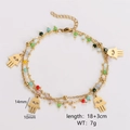 Detail of gold double-layer bracelet with colorful beads and Hamsa Hand charms - Hamsa Hand