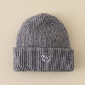 Close-up of grey ribbed knit beanie with a white heart embroidery and folded cuff - Hat / Gray