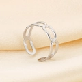 Detailed view of silver chain-link stainless steel ring on soft beige silk background - Hollow Interwoven Chain Style (KR105022-KFC)