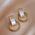 Detailed close-up of golden metal earrings with white faux cat-eye stone on silk fabric - Gold Circle (S925 Silver Pin)
