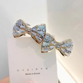 Pince à cheveux dorée élégante avec strass bleus et clairs et design à double nœud - Style Deux Nœuds