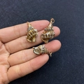 Three natural seashell pendants with gold plated edges and loops on a hand palm - No.32 (Brown White Spotted Conch - Gilded Edge)