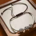 Detail of vintage silver metal beads and brown braided cord on a textured linen display - 3 Beads Bracelet