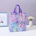 Floral non-woven gift bag with purple handles displayed next to a white flower vase - Purple Floral (4004-1) / Small 23*22*11cm
