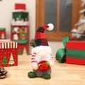 Gnomo de Navidad con gorro de cuadros rojos y barba blanca sobre mesa de madera - Estilo de sombrero a cuadros