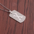 Gros plan détaillé d'un collier plaque d'identité en acier inoxydable avec découpe d'os - Lettre X
