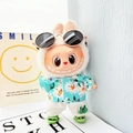 Plush doll in green floral shirt and sunglasses from the sitting party collection - Green Shark Shoes + Sky Blue Beach Outfit / First And Second Generation Keychains Are Compatible With La Cloth Dolls. Dolls Not Included.