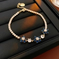 Macro detail of gold flower tennis bracelet with blue and clear zircon gemstones - Blue Zirconia / Gold