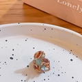 Mini brown tortoiseshell hair claw clip with marble pattern on a ceramic plate - Green Brown Pattern
