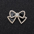 Elegant black enamel bow charm with white faux pearls and a sparkling central crystal - Gold Base Black Bow