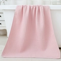 Absorbent pink waffle weave cotton bath towel hanging on a white bathtub in a bathroom - 70*140cm / Lotus Pink