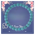 Detail eines Türkis-Perlenarmbands mit Herzanhänger auf einer Muttertags-Geschenkkarte - An meine beste Mama / Türkis