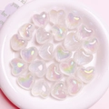 Macro shot of iridescent heart-shaped aurora beads in a white ceramic dish for DIY crafts - 1 Bead / White