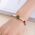 Détail du bracelet ethnique avec perles blanches et charm cloche dorée vintage - Exaucer Tous les Vœux