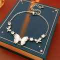 Prachtige vlinderarmband met zirkonia-inleg op een donkerblauw antiek boek - Zilver