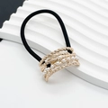 Close-up of black elastic hair tie featuring gold metal twist band and white pearls - Small / Gold
