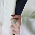 Dettaglio di un anello a fascia larga in argento con due gemme ovali verde smeraldo - US 6 / Argento/Zircone Verde