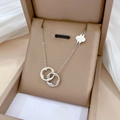 Macro shot of silver four-leaf clover pendant necklace inside a luxury brown jewelry box - Double Ring Clover Pendant (N235) / Silver