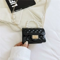 Bolso acolchado negro con asa de perlas y cadena dorada mostrado elegantemente en la mano - Negro