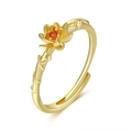 Detail of gold lotus ring with red gemstone and textured branch-style band design - July