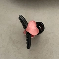 Dettaglio di un fermaglio per capelli nero in plastica con cuore rosa 3D su fondo grigio - Taglia Piccola / Nero