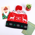 Detail of Christmas knitted hat with pom-pom, reindeer patterns and festive holiday decor - Red White Double Reindeer
