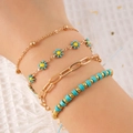 Set van vier gouden bloemenarmbanden met kleurrijke madeliefjes en turquoise kralen - Meerlaagse Kralenstijl / Blauw - Armband