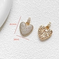 Detail of 28.5mm golden heart pendant showing cubic zirconia inlay and hollow floral pattern - Letter V