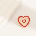 Macro shot of a heart-shaped enamel brooch with concentric red and pink stripes on white - Red Heart