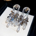 Dettaglio degli orecchini pendenti con perle e strass dorati in stile barocco retro - Argento