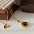 Golden necklace with brown round gemstone pendant on a warm elegant velvet jewelry box - Oval Pendant Necklace