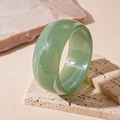 Vue détaillée d'un bracelet en acrylique vert marbré sur un socle en pierre - Vert