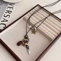Detailed close-up of retro bohemian pendant necklace with star, feather and blue gemstone - Alloy/Wood/Faux Turquoise / Retro Star Feather Style (1#)