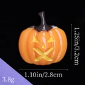 Vista macro che mostra le dimensioni del ciondolo zucca in resina: 3,2cm per 2,8cm - Zucca con Occhi Gialli - Arancione Brillante