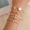 Détail d'un ensemble de 5 bracelets dorés avec lune, plume et cristal sur un modèle - Ensemble de 5 bracelets plumes de lune dorées (3002)